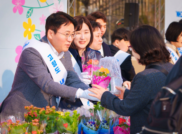 이석용 NH농협은행장(왼쪽)이 출근길 시민에게 미니화분을 주며 인사를 나누고 있다. 사진 제공=NH농협은행