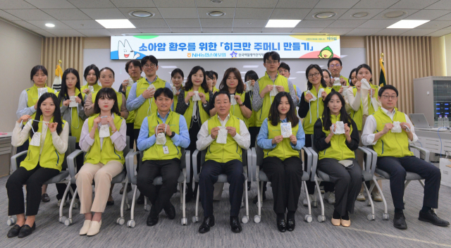 NH농협손해보험은 지난 28일 서울 성북구 소재 ‘한국백혈병어린이재단’을 방문해 ‘히크만주머니’와 치료비를 전달했다. 이에 앞서 지난 23일 최문섭(앞줄 왼쪽 네 번째) 대표이사와 임직원들이 히크만주머니 제작 후 기념사진 촬영을 하고 있다. 사진 제공=NH농협손보