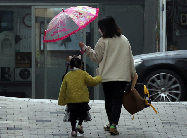 서울 시내에서 한 어린이가 엄마와 어린이집에 가고 있는 모습. 연합뉴스