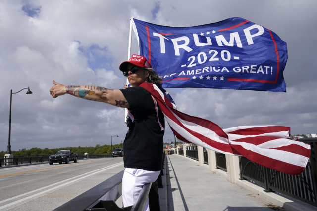도널드 트럼프 전 대통령의 지지자가 1일(현지시간) 미국 플로리다주에 위치한 트럼프의 리조트 인근에서 그를 지지하는 깃발을 들고 서 있다. AP연합뉴스
