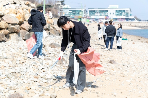 HMM 신입사원과 임직원들이 거잠포해변에서 쓰레기를 줍고 있다. 사진 제공=HMM