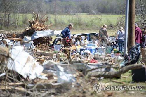 (미국 테네시주 애덤스빌을 지난달 31일 덮친 토네이도에 집이 완전히 파괴된 피해자 가족들이 식탁 의자 등 가재도구를 챙기고 있다. AP=연합뉴스