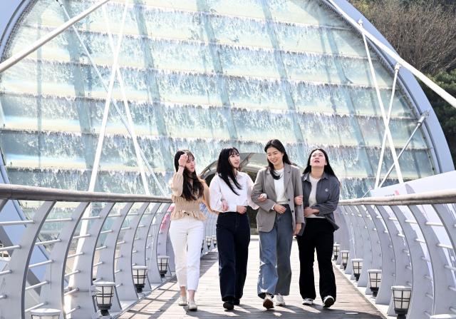 3일 오전 새봄을 맞아 가동을 시작한 서울 서초구 남부순환로 예술의 전당 앞 아쿠아아트육교에서 시민들이 쏟아지는 물줄기를 보며 육교를 건너고 있다. 권욱 기자 2023.04.03