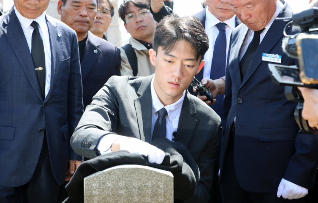 전우원 씨가 지난 31일 광주 북구 운정동 국립 5.18 묘지 내 1묘역 고 김경철 열사 묘비를 닦고 있다. 연합뉴스