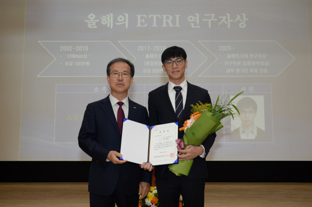 한국전자통신연구원(ETRI) 방승찬(왼쪽) 원장이 올해의 ETRI 연구자상 수상자인 강찬모(오른쪽) 박사에게 표창장을 수여하고 기념촬영을 하고 있다. 사진제공=ETRI