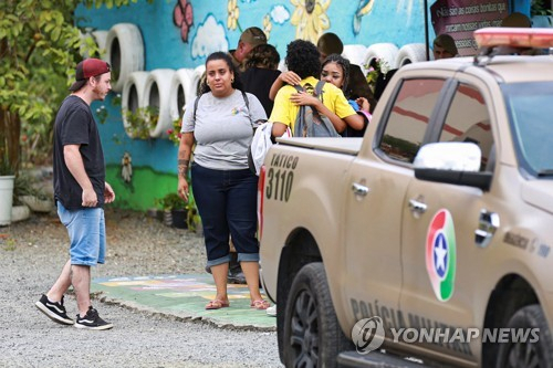 5일(현지시간) 브라질 산타카타리나주 블루메나우 한 어린이집 밖에서 시민이 서로 안아주고 있다. 이날 오전 이곳에서는 괴한의 흉기에 유아 9명이 숨지거나 다쳤다. 로이터=연합뉴스