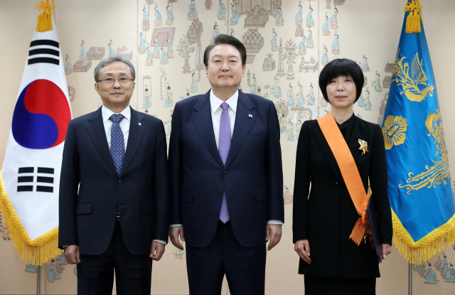 윤석열 대통령이 6일 서울 용산 대통령실 청사에서 이선애 전 헌법재판관에게 청조근정훈장을 수여한 뒤 기념촬영을 하고 있다. 왼쪽은 유남석 헌법재판소장./연합뉴스