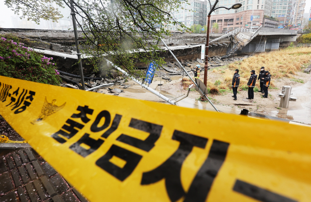 5일 오전 교량 양쪽에 설치된 보행로 중 한쪽 보행로가 갑자기 무너져 내리면서 1명이 숨지고 1명이 다치는 사고가 발생한 경기도 성남시 정자교에서 소방 등 관계자들이 분주하게 움직이고 있다. 연합뉴스