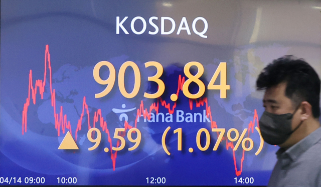 14일 코스닥은 전일보다 9.59포인트(1.07%) 오른 903.84, 코스피는 전일보다 9.83포인트(0.38%) 오른 2,571.49로 마감했다. 서울 중구 하나은행 딜링룸에서 직원이 전광판 앞을 지나고 있다. 연합뉴스