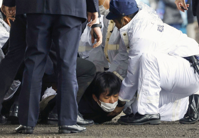 15일 오전 11시 30분께 일본 오사카부 남쪽 와카야마현 사이카자키 어시장에서 기시다 후미오 일본 총리를 향해 은색 통에 담긴 폭탄을 던진 용의자 기무라 유지(24·가운데)가 경찰 등에 의해 체포되고 있다. 교도연합뉴스