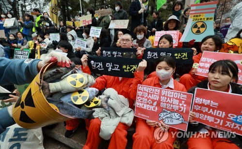 11일 일본 후쿠시마 원전 사고 12주기를 앞두고 9일 중구 서울파이낸스센터 앞에서 열린 '탈핵 행동의 날' 집회에서 환경운동연합 등 시민사회·환경단체 회원들이 정부의 핵 진흥 정책과 일본의 후쿠시마 원전 오염수 방류를 반대하며 손팻말과 펼침막을 들어보이고 있다. 연합뉴스