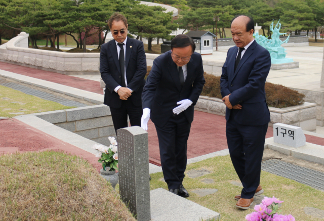 김재원(가운데) 국민의힘 최고위원이 지난 14일 오전 광주 북구 5·18 민주묘지를 방문해 참배하고 있다. 김 최고위원은 “5·18 정신을 헌법 전문에 반영할 수 없다”는 취지의 발언을 했다가 비판이 일자 사과했다. 연합뉴스