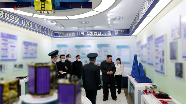 김정은 북한 국무위원장이 국가우주개발국에서 현지 지도를 하고 있다. 정찰위성으로 추정되는 물체 2개가 식별된다.