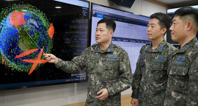 최성환(왼쪽) 공군 우주센터장이 센터원들과 함께 콤스폭이 제공하는 위성 흐름 정보를 보며 우주위협 감시에 관해 논의하고 있다. 사진 제공=공군본부