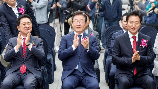 20일 서울 종로구 광화문광장에서 열린 제59회 한국보도사진전 개막식에 김기현(왼쪽부터) 국민의힘 대표, 이재명 더불어민주당 대표, 오세훈 서울시장이 참석해 박수치고 있다. 연합뉴스