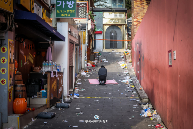 <59회 한국보도사진상 - 대상> 이태원 참사 현장 골목에서 오랜 시간 장사를 해온 한 상인이 31일 서울 용산구 이태원 사고 현장에서 희생자들을 위한 제사를 지내고 있다. 사진 제공=한국사진기자협회