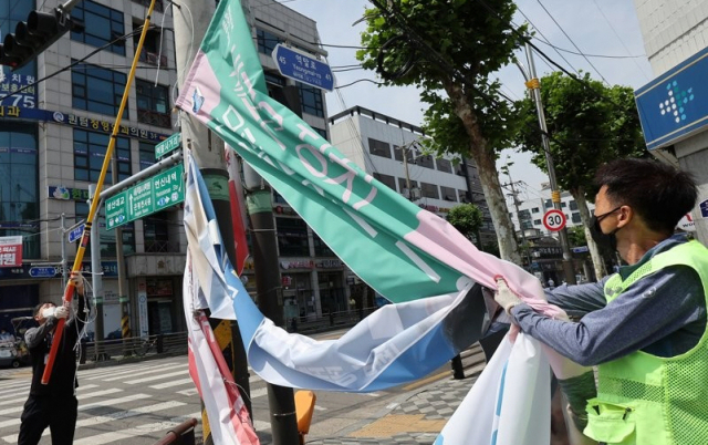 지난해 6월 2일 서울 은평구 역말사거리에서 은평구청 광고물 정비팀 직원들이 제8회 전국동시지방선거에 출마한 광역, 기초 자치단체장, 지방의회 의원, 교육감 등 출마 후보자들의 현수막을 철거하고 있다. 연합뉴스