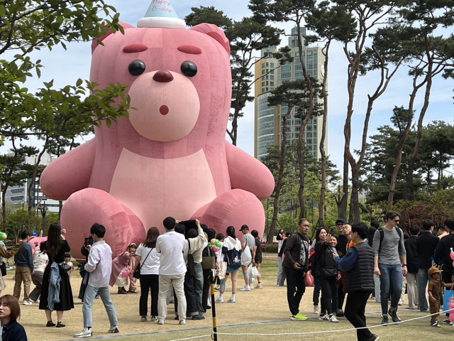 22일 롯데타워 뒤편에 세워진 ‘벨리곰’을 찾은 방문객들이 줄을 서서 사진을 촬영하고 있다./사진=황동건 기자