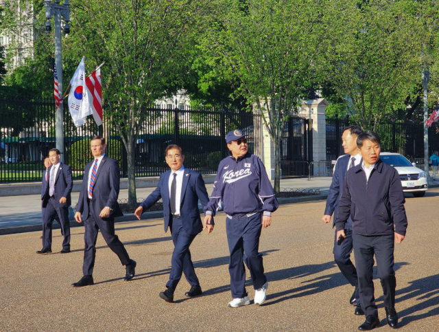 미국을 국빈 방문한 윤석열 대통령이 25일(현지시간) 워싱턴DC 백악관 인근에서 바이든 대통령이 지난해 방한 당시 선물한 모자와 선글라스, 대한민국 국가대표 야구팀 점퍼와 시구 때 신었던 국산 브랜드의 운동화를 신고 산책하고 있다. /연합뉴스