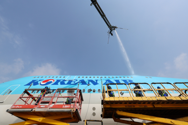 17일 오전 영종도 인천국제공항 대한항공 정비 격납고에서 관계자들이 B747-8i 항공기 동체를 세척하고 있다. 연합뉴스