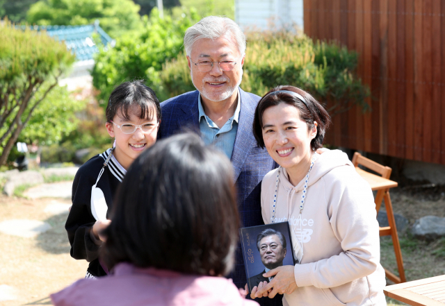 문재인 전 대통령이 26일 오후 경남 양산시 하북면 자신의 책방 '평산책방' 앞 마당에서 지지자와 기념 촬영하고 있다. 연합뉴스