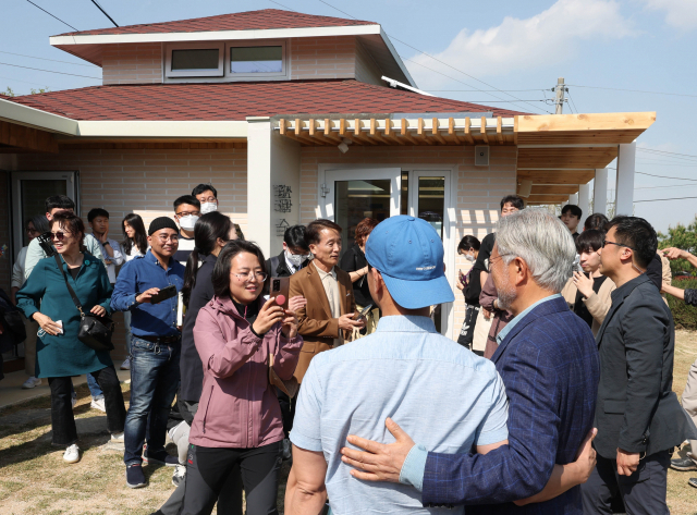 문재인 전 대통령이 26일 오후 경남 양산시 하북면 자신의 책방 '평산책방' 앞마당에서 지지자 및 손님과 기념 촬영하고 있다. 연합뉴스