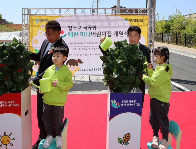 함영주(오른쪽) 하나금융그룹 회장과 김재욱(왼쪽) 칠곡군수가 지난 28일 경복 칠곡군 국공립 칠곡 왜관 하나 어린이집 개원식에서 칠곡 왜관하나어린이집 원아들과 함께 화분에 물을 주는 퍼포먼스를 하고 있다. 사진 제공=하나금융