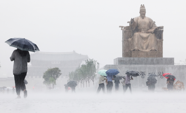 우산을 쓴 시민들이 서울 광화문광장을 지나고 있다. 연합뉴스