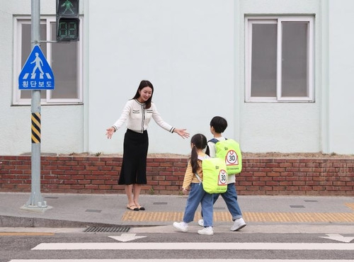 삼성전자 모델이 '아이 라이크 제트 봇 AI' 캠페인 일환으로 제작한 '스쿨존 가방 안전 커버' 굿즈를 선보이고 있다. 사진제공=삼성전자