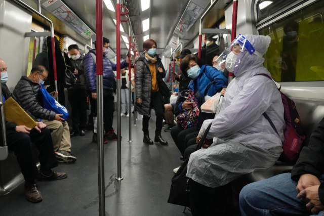 한 여성이 마스크와 방호복을 입고 홍콩의 지하철 좌석에 앉아 있다. AP=연합뉴스