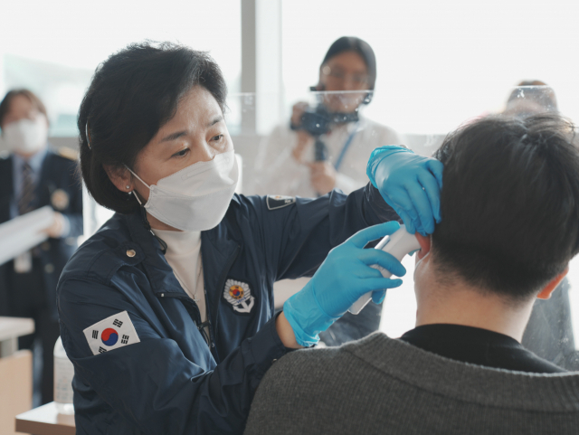 일일 검역관으로 나선 지영미 질병관리청장이 지난 2일 인천공항에서 감염병 환자 역할을 맡은 한 입국객의 체온을 측정하고 있다. 사진 제공=질병청