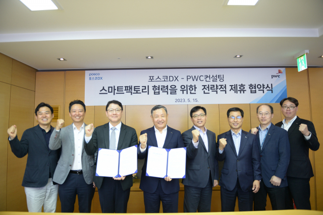 정덕균(왼쪽 네번째) 포스코DX 대표와 문홍기(왼쪽 세번째) PwC컨설팅 부대표를 비롯한 회사 관계자들이 15일 포스코DX 판교사옥에서 스마트팩토리 사업협력을 위한 업무협약을 체결하고 기념 촬영을 하고 있다.사진제공=포스코DX