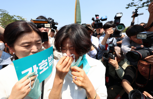 16일 오전 서울 용산 대통령 집무실 앞에서 대한간호협회 주최로 열린 간호법 공포 촉구 기자회견이 끝난 뒤 한 참가자가 눈물을 흘리고 있다. 연합뉴스