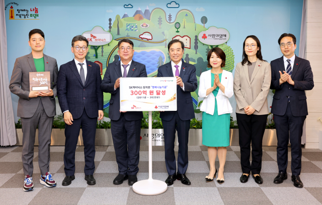 김동섭(왼쪽 세 번째) SK하이닉스 대외협력 사장과 김병준(〃 네 번째) 사랑의열매 사회복지공동모금회 회장이 16일 감사패 전달식에서 ‘누적 행복나눔기금 300억 원’ 기념 팻말을 들어 보이고 있다. 사진 제공=SK하이닉스