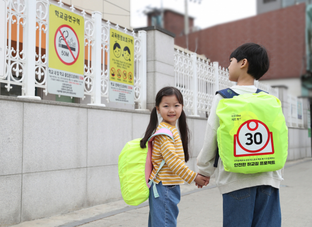 사진은 삼성전자와 크라운제과가 '아이 LIKE 제트 봇 AI' 캠페인 일환으로 제작한 '스쿨존 가방 안전 커버' 굿즈를 선보이고 있다. 연합뉴