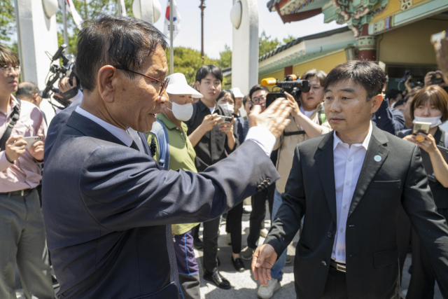 17일 오전 광주 북구 운정동 국립 5·18민주묘지 입구에서 황일봉 5·18부상자회장(왼쪽)이 강기정 광주시장 일행을 향해 소리치고 있다. 이날 5·18묘지 입구에서는 5·18교육관 위탁 사업자 선정을 둘러싼 5·18 일부 단체와 강 시장 간 갈등이 표출됐다. 광주=연합뉴스