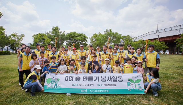 OCI 임직원 및 가족들이 20일 서울 이촌한강공원에 ‘OCI 숲’ 조성 활동을 마친 후 기념 촬영을 하고 있다. 사진 제공=OCI홀딩스