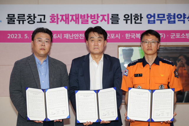 하은호 군포시장(가운데)와 기송 한국복합물류(주) 대표(왼쪽), 고문수 군포소방서장(오른쪽)이 24일 시청 재난상황실에서 물류창고 화재재발 방지와 피해 최소화를 위한 공동노력이 담긴 업무협약을 맺고 있다. 사진 제공 = 군포시