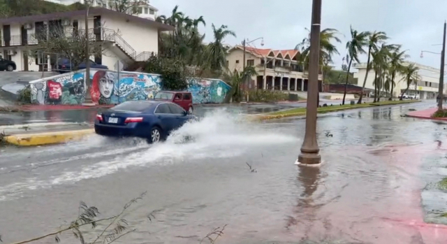 시속 241㎞의 돌풍을 동반한 '슈퍼 태풍' 마와르가 태평양의 미국령 괌을 강타한 지난 25일(현지시간) 한 자동차가 투몬 만의 침수된 거리를 지나가고 있다./AFP=연합뉴스
