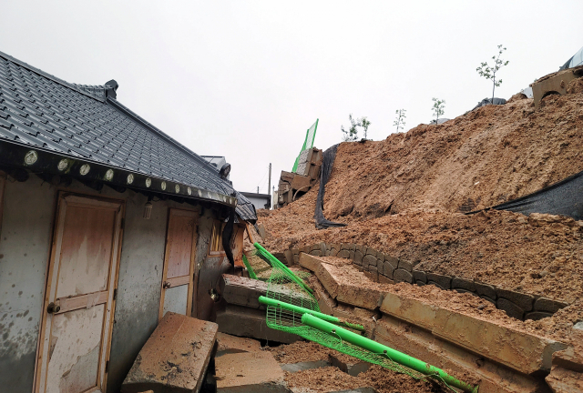 전북 대부분 지역에 호우 특보가 내려진 29일 오전 전북 완주군 봉동읍 한 주택 인근 축대가 무너져 토사가 흘러내리고 있다. 전북소방본부 제공