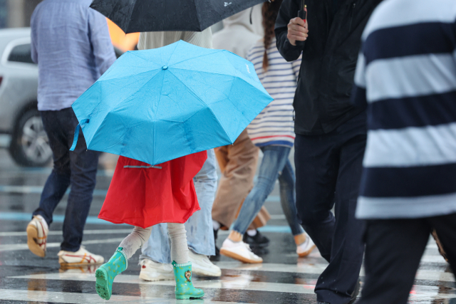 지난 27일 서울 광화문네거리에서 어린이가 우산을 쓰고 횡단보도를 건너고 있다. 연합뉴스