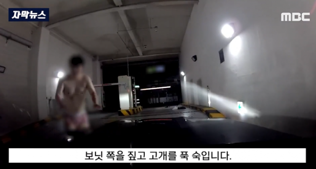 주차장 출구에 드러누워 있다가 옷을 벗은 채 여성 운전자에게 다가가 행패를 부린 남성. MBC 보도화면 캡처