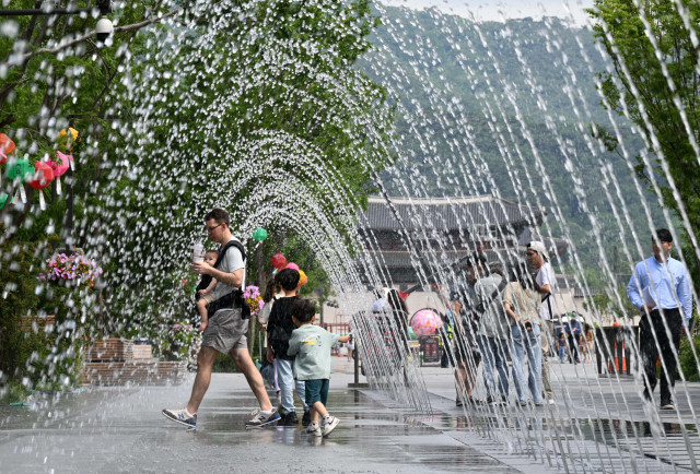 덥고 습한 날씨가 지속된 30일 오후 광화문광장 분수대에서 어린이들이 분수대에서 물놀이를 즐기고 있다. 권욱 기자