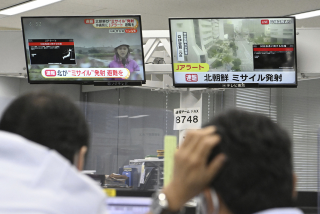 31일 일본 도쿄에서 주민들이 TV 화면에 뜬 북한 미사일 관련 속보를 바라보고 있다. 이날 오전 일본 정부는 전국순시경보시스템(J-ALERT)을 통해 대피 명령을 내렸지만 약 30분 만에 해제했다. AP연합뉴스