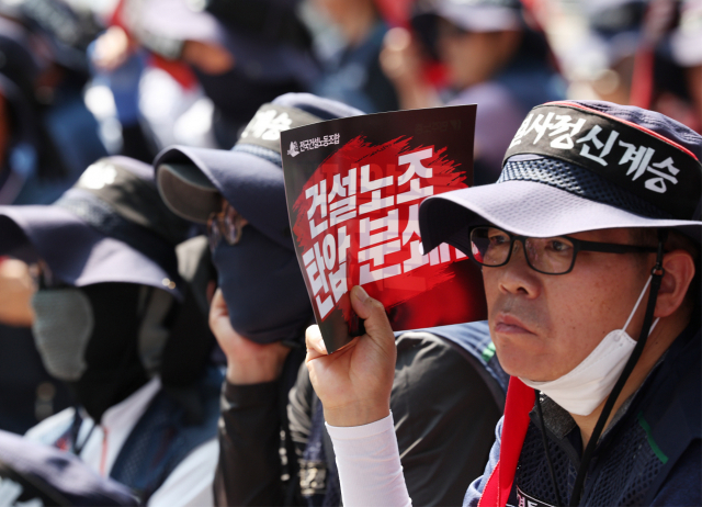 31일 오후 서울 용산구 대통령실 인근에서 열린 민주노총 경고파업 결의대회의 사전집회에서 건설노조 조합원이 손팻말을 들고 있다. 연합뉴스