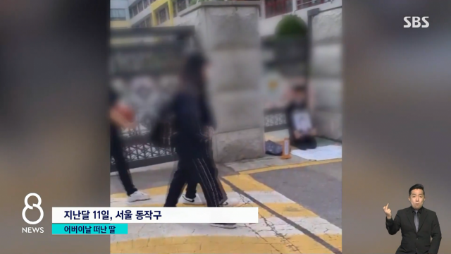 지난달 11일 서울 동작구의 한 중학교 앞에서 딸의 영정을 들고 억울함을 호소하는 아버지. SBS 보도화면 캡처