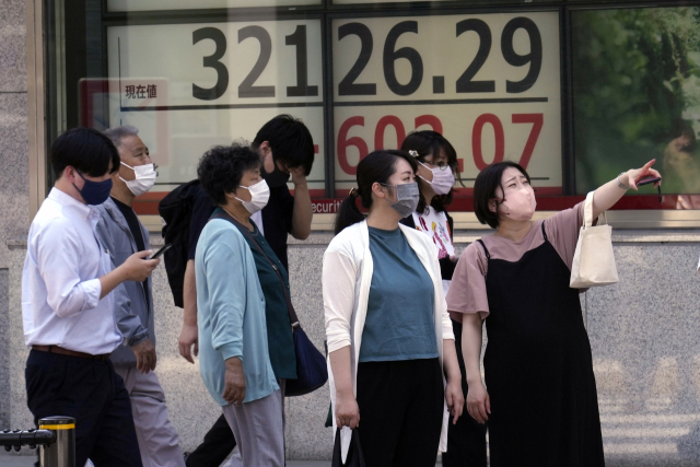 5일 도쿄에서 시민들이 닛케이225 지수가 3만 2000선을 넘었다는 내용을 보여주는 전광판 앞에 서 있다. AP연합뉴스