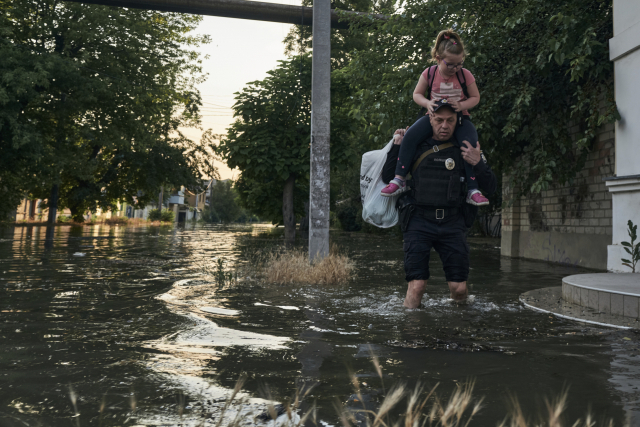 6일(현지 시간) 우크라이나 헤르손 지역 주민이 침수된 지역에서 대피하고 있다. 우크라이나 남부 지역의 댐이 파괴되면서 홍수가 발생했고 식수공급이 위협받고 있다. AP연합뉴