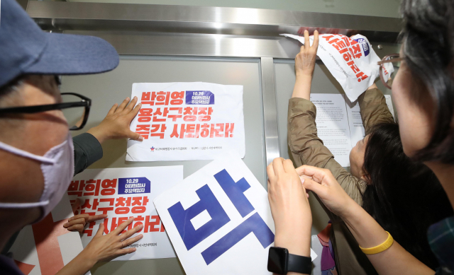 8일 오전 서울 용산구청에서 이태원 참사 유가족들이 박희영 용산구청장 사퇴 촉구 손팻말을 붙이고 있다. 공동취재단