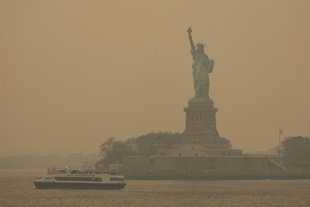 The Statue of Liberty, covered in a haze-filled sky, is photographed from the Staten Island Ferry, Wednesday, June 7, 2023, in New York. (AP Photo/Yuki Iwamura)